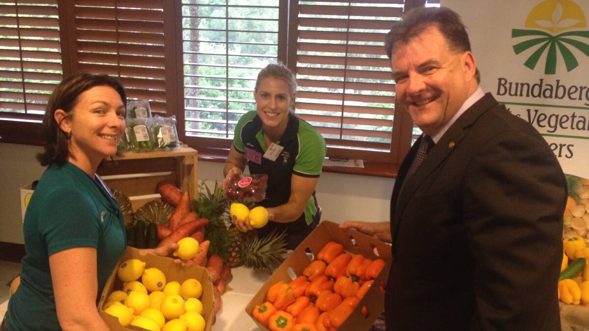 PRODUCE PLUS: Bundaberg Fruit and Vegetable Growers’ Kylie Jackson and Bree Grima with Member for Burnett Stephen Bennett setting up for the Bundaberg Region Promotion Night at Queensland Parliament House last week.