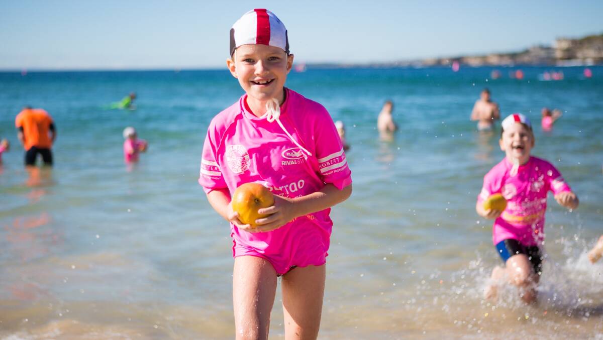 SUMMER’S HERE: North Bondi Surf Life Saving Club nippers race out of the water carrying mangoes as part of the industry’s Mango Mess-tival marking the start of summer and the peak of mango production. 
