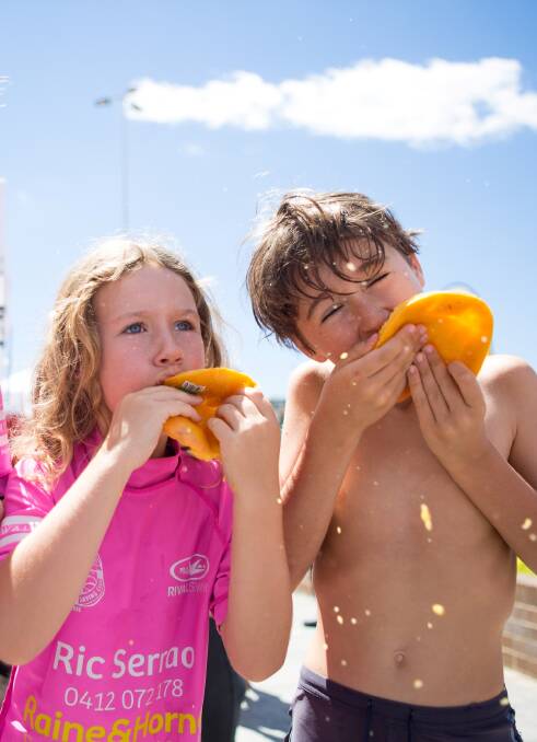 MOUTHFULS: Two young mango lovers get stuck into their fruit of choice.