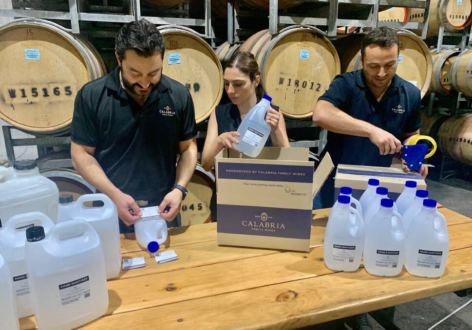 ON DECK: Michael Calabria, Elizabeth Calabria-Staltare and Andrew Calabria packaging hand sanitiser produced by the winery for health services. Photo: Calabria Family Wines