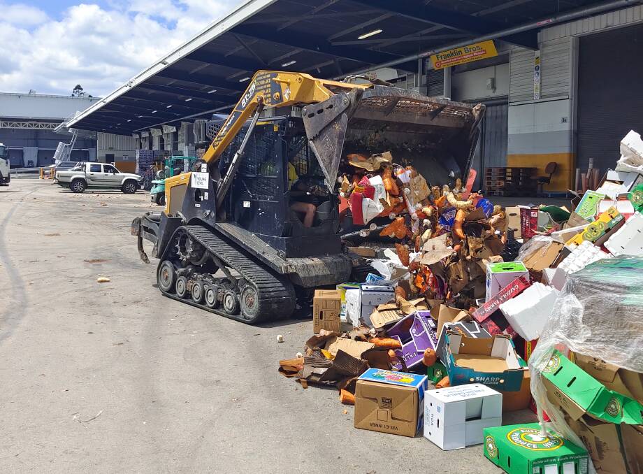 TASK: Part of the clean up at the Brisbane Produce Market after flood waters went through the facility earlier this week. 