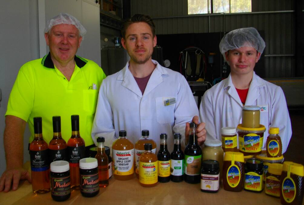 FRESH: Martin and Lachlan Drake and work experience student Caleb Kilpatrick with some of the bulk local and imported liquid food products they package and label.